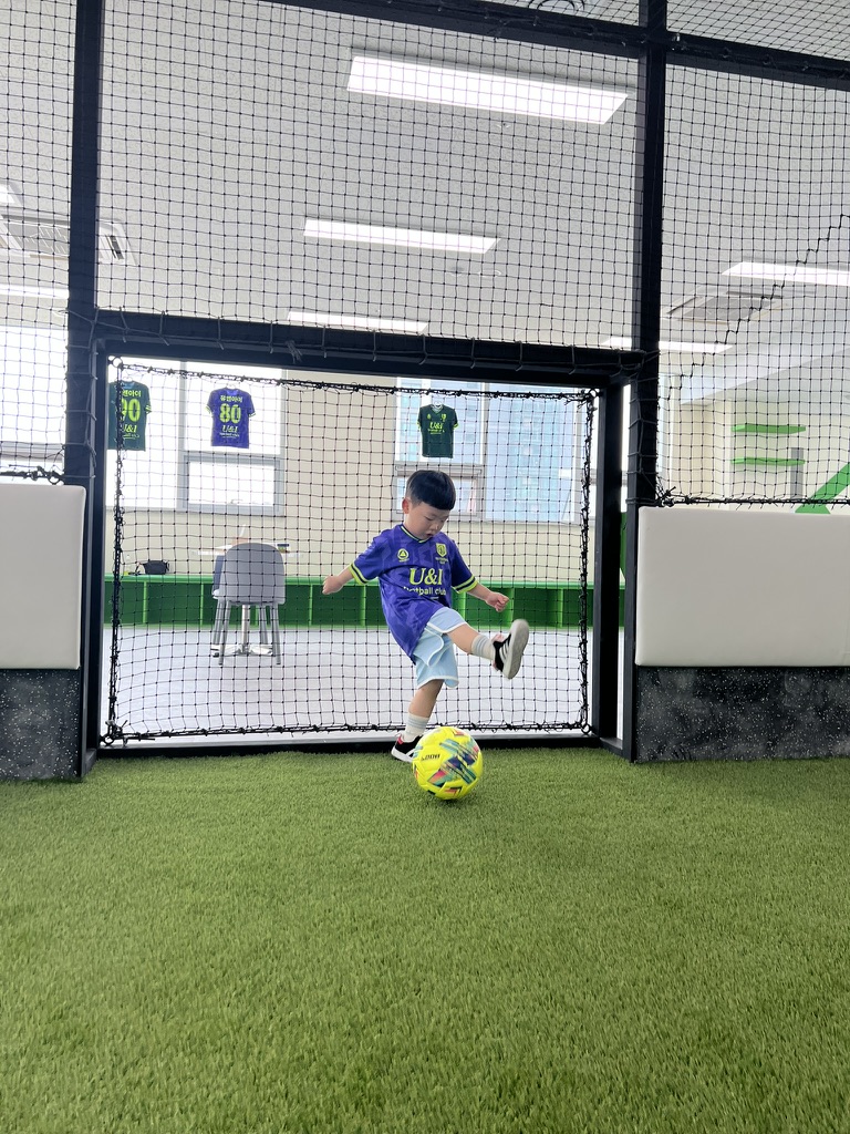 축구공을 향해 달려가는 아이의 역동적인 모습과 함께 신체 발달을 나타내는 성장 그래프와 두뇌 발달을 상징하는 뉴런 이미지가 시각적으로 표현된 사진